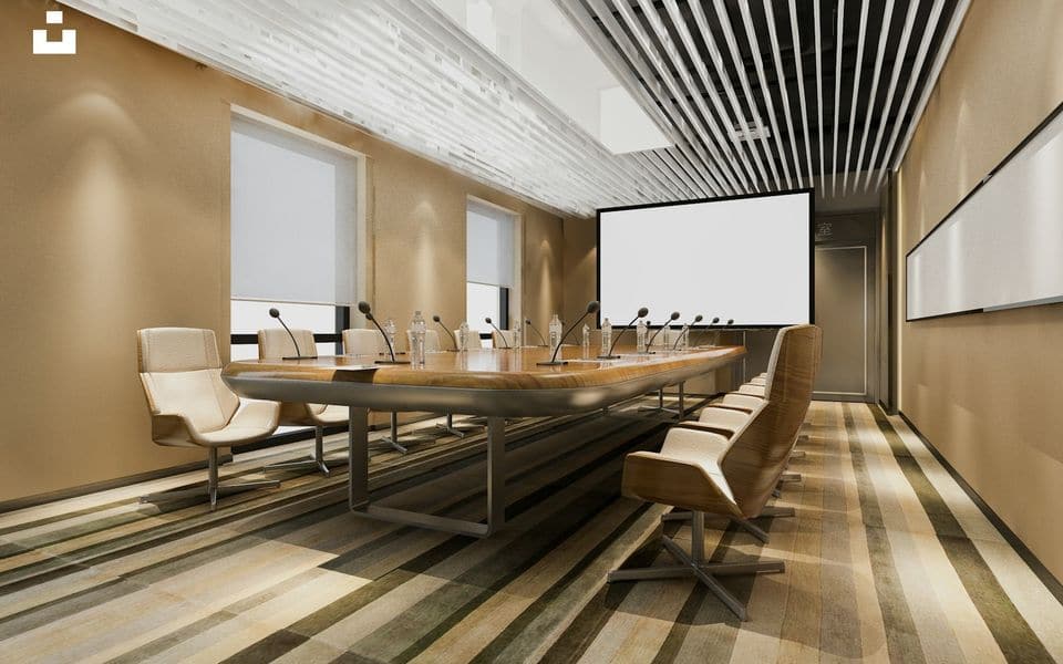 Executive boardroom featuring a conference table and a wall-mounted presentation screen