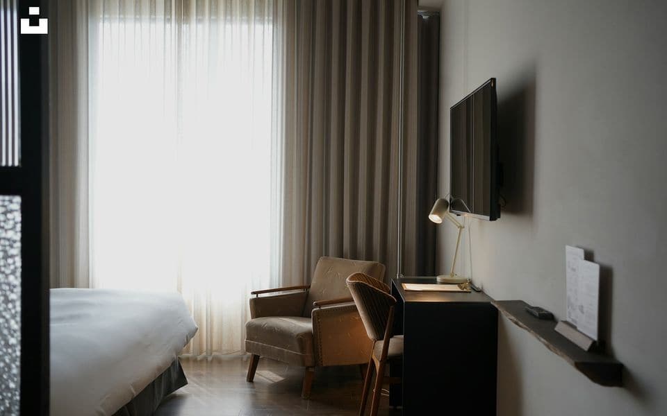 Modern hotel guest room with wall-mounted flat-screen television and desk
