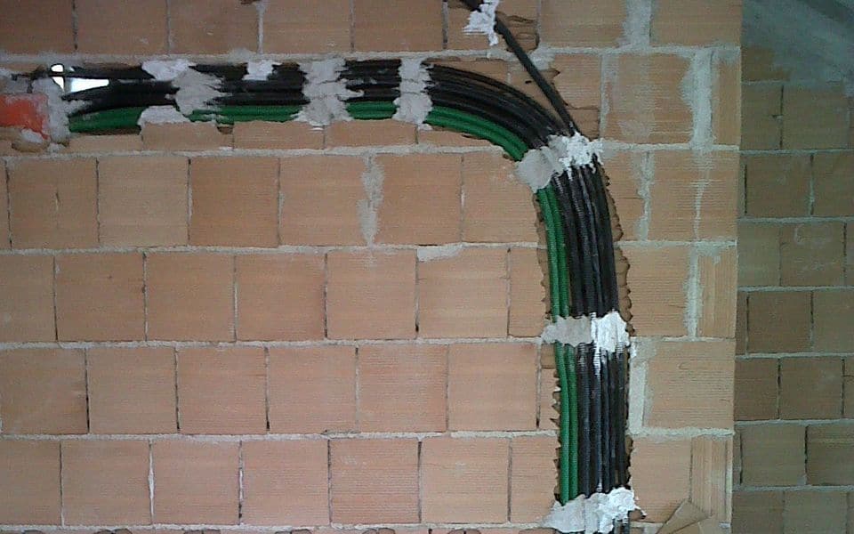 Electrical conduit and cables routed on a masonry wall in a building under construction