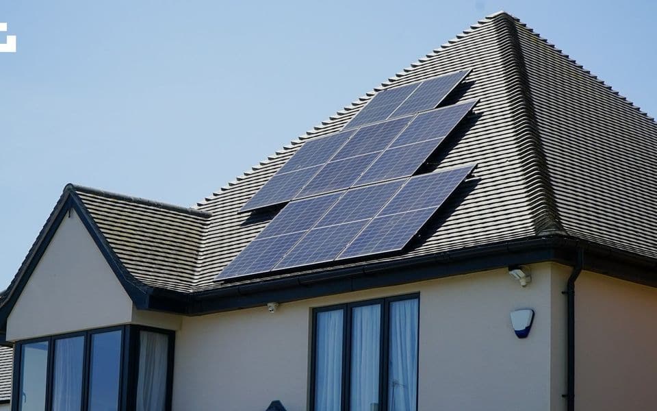 Commercial rooftop photovoltaic solar panel array installed on roof under clear sky