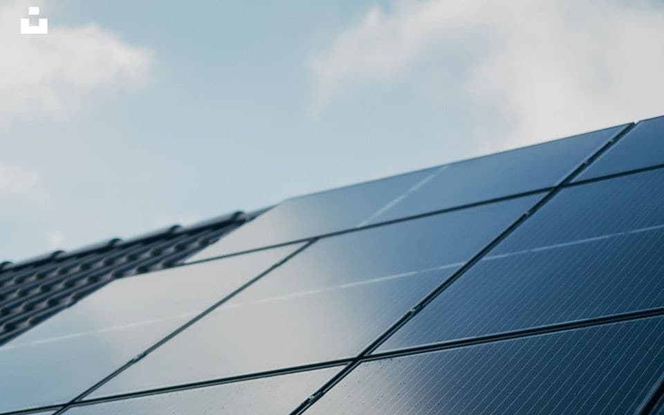 Close-up of photovoltaic solar panel cells with aluminum mounting frame under clear sky